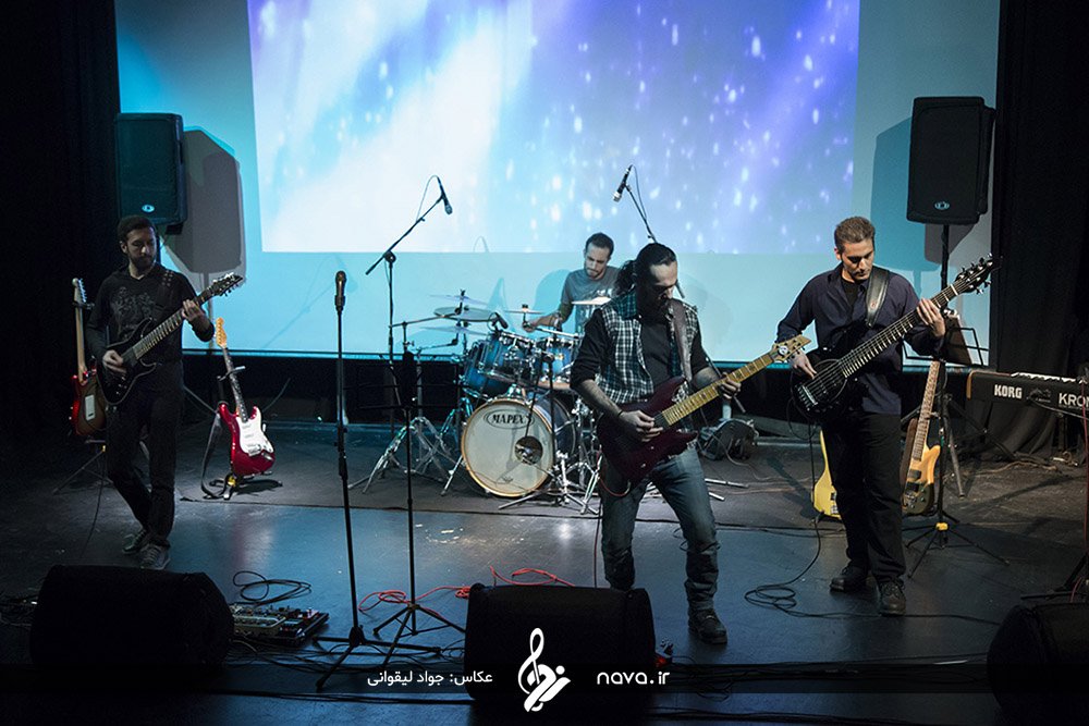Full band on stage under projected lights